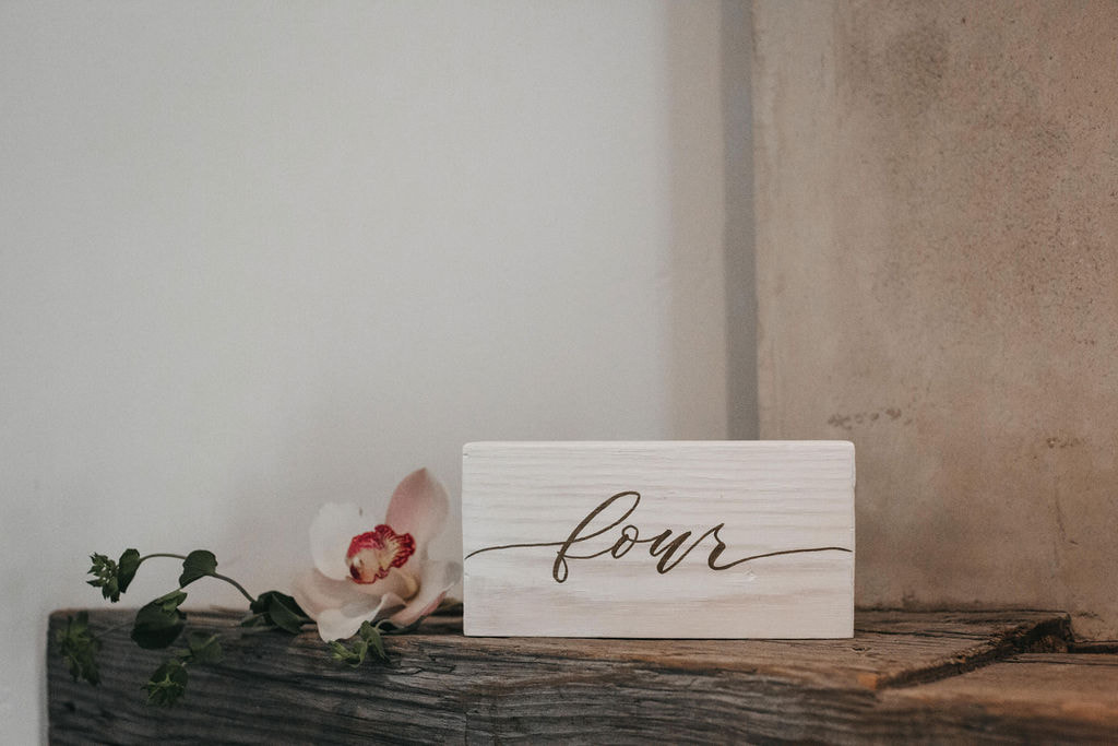White wood table number with gold lettering